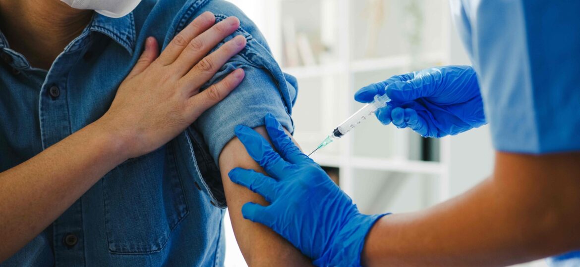 A nurse injects vaccine into a patient.
